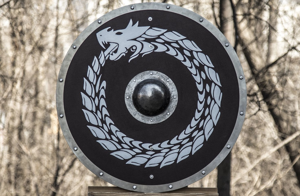Handcrafted wooden Viking shield with iron boss and Norse knotwork design