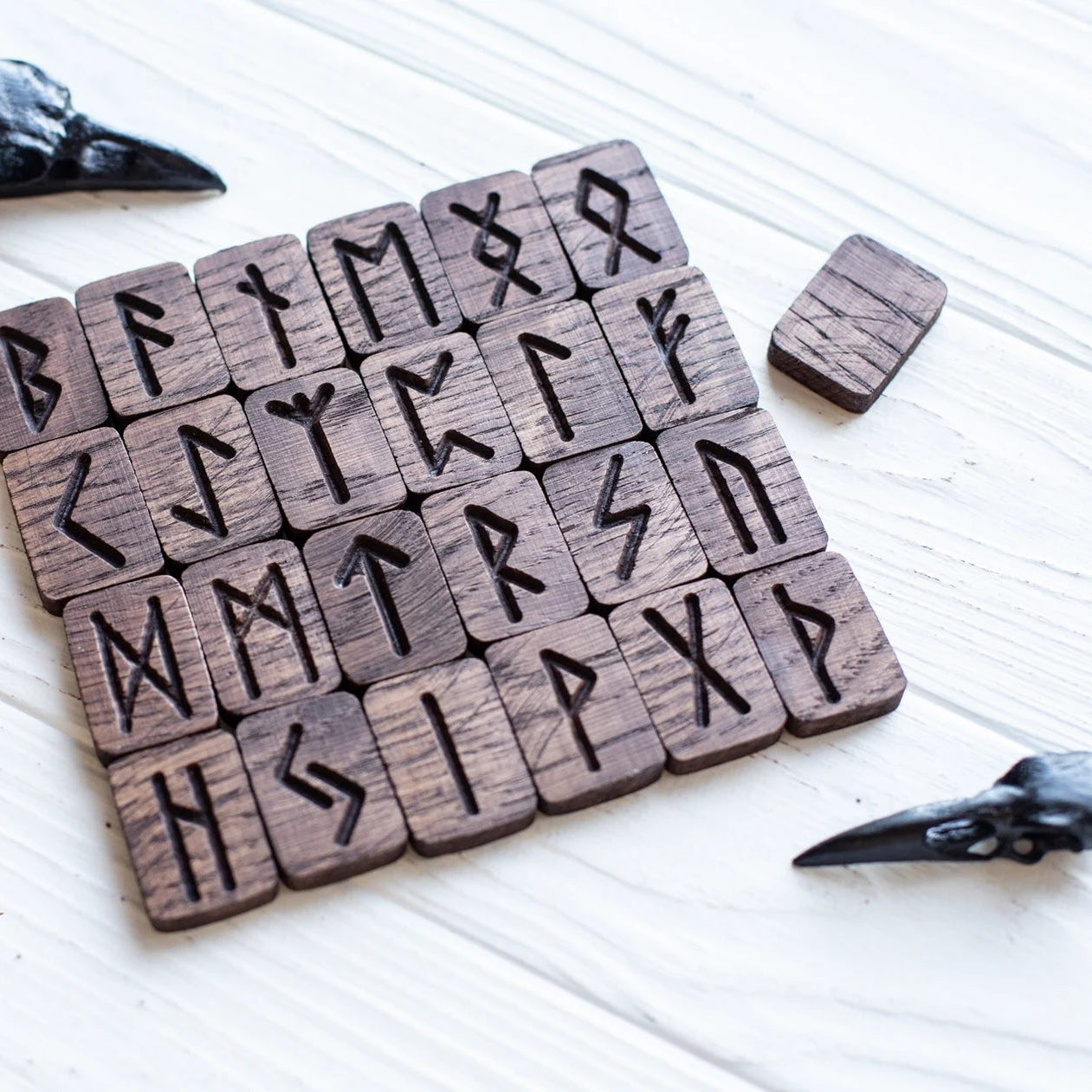 Set of wooden stamps with engraved runes on a white surface.